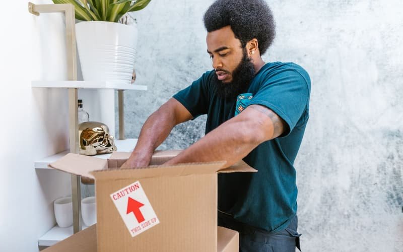 Mover carefully packing items from a shelf